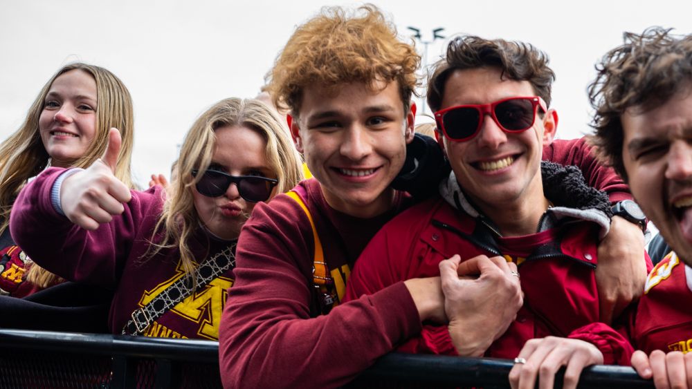 Students wearing gopher gear posing in the crowd