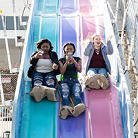 Image of attendees going down a giant slide.