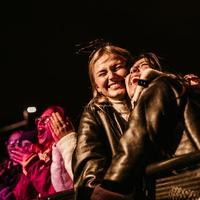 Friends hugging and smiling in the concert crowd