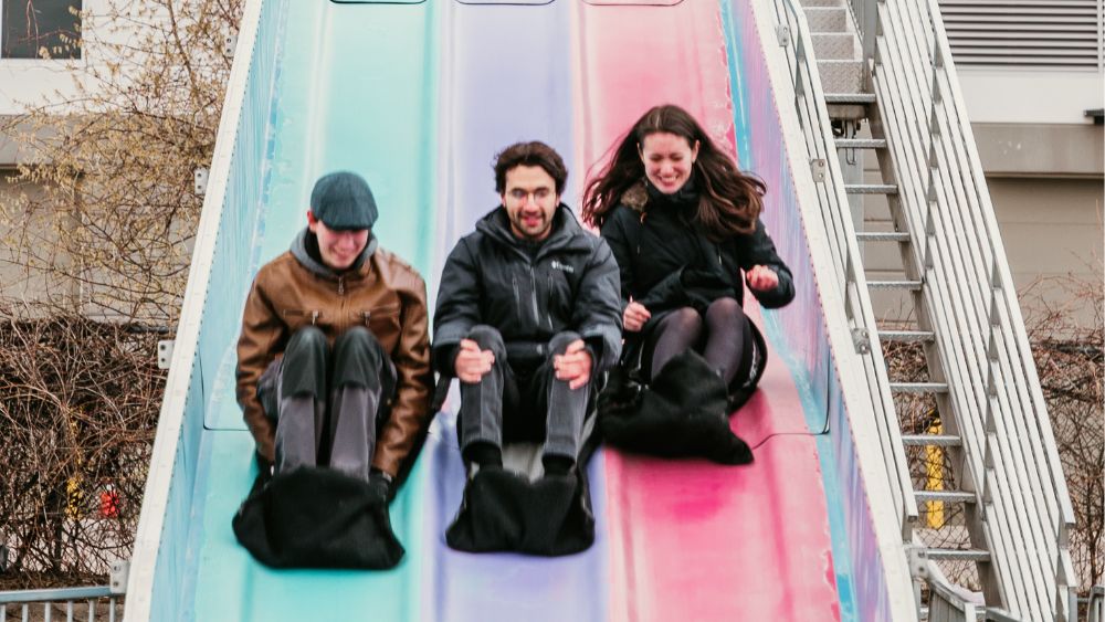 Students smiling while sliding down the "Fun Slide"